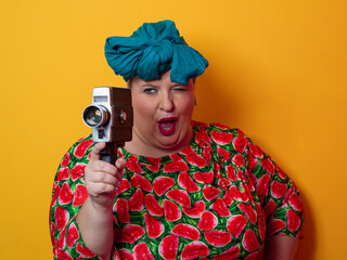 Retro plus size woman filming with vintage camera