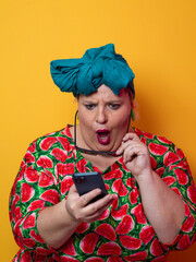 Surprised plus-size woman looking at smartphone with wide expression