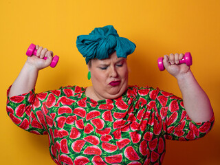 Funny plus size woman lifting dumbbells in watermelon dress