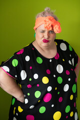 Plus size woman in vibrant polka dot outfit making a comic shrug gesture with outstretched hands and amusing expression.
