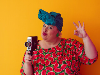 Retro plus size woman filming with vintage camera