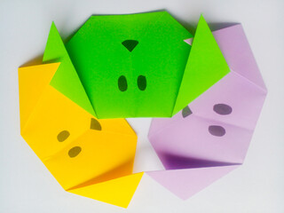 Origami yellow, green, and purple dog head isolated on white background.