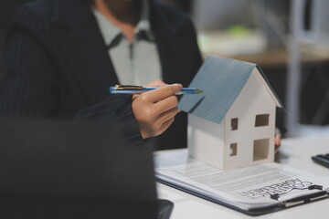 Real estate agents explain models of housing estates in projects to elaborate to clients, explaining and presenting information about homes and purchasing loans. Real estate trading concept.