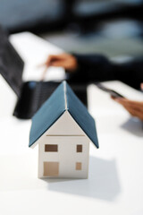 Real estate agents explain models of housing estates in projects to elaborate to clients, explaining and presenting information about homes and purchasing loans. Real estate trading concept.