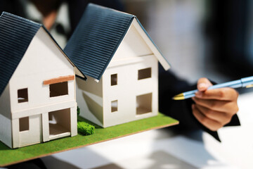Real estate agents explain models of housing estates in projects to elaborate to clients,...