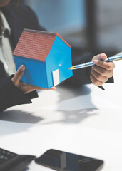 Real estate agents explain models of housing estates in projects to elaborate to clients, explaining and presenting information about homes and purchasing loans. Real estate trading concept.