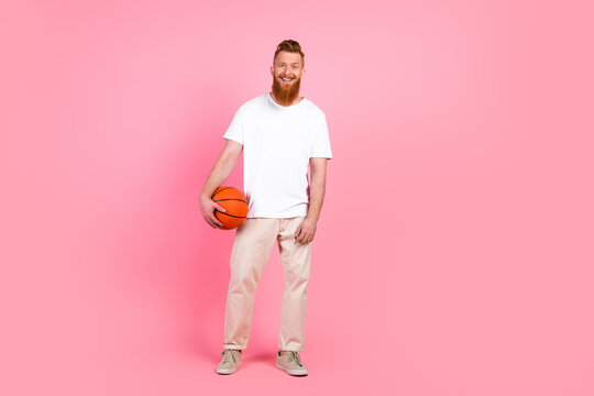 Bearded man with a basketball on a pink background showcasing casual fashion and lifestyle vibes