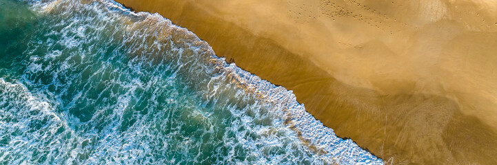 Florianópolis, Campeche beach during sunrise. Brazil. Rio Tavares neighborhood. Wave formation in web banner aerial view.