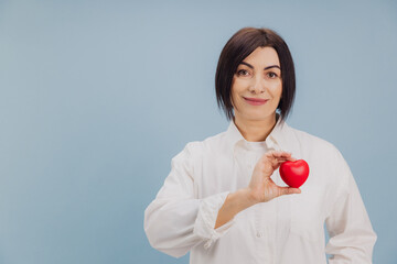 Middle Aged Woman Showing Red Heart Promoting Healthcare and Cardiovascular Wellbeing