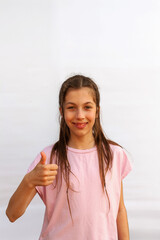 I like it. Portrait of joyful teenage girl showing thumbs up and smiling at camera, white background Vertical photography