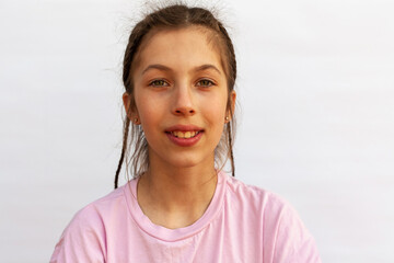 Girl with big smile showing crooked teeth, malocclusion on white background