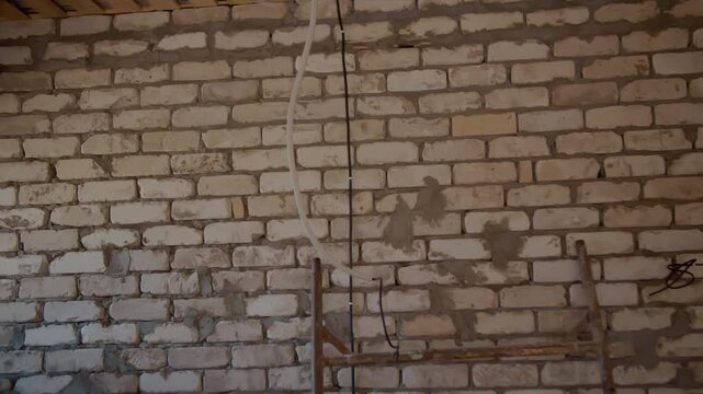 Brick wall with electrical wiring in unfinished interior