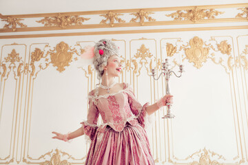A young woman in an elegant pink baroque gown stands in a luxurious palace interior, holding a...