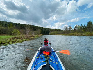 A person expertly paddles a vibrant kayak down a lively river, enjoying the breathtaking scenery and excitement of this joyful, adventurous activity that brings relaxation