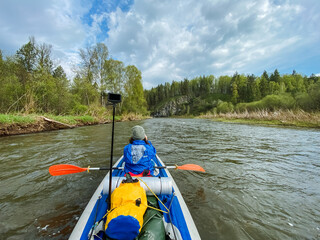 A person skillfully paddles a colorful kayak down a serene river, enjoying the beautiful scenery and the calming tranquility of nature during this popular outdoor activity