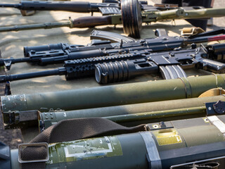 A bunch of guns are lined up on a table