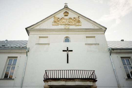 Facade of a historic monastery church with crucifix and ornamental relief details in Yazlovets, Ukraine.