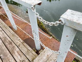 A white railing with a chain attached to it