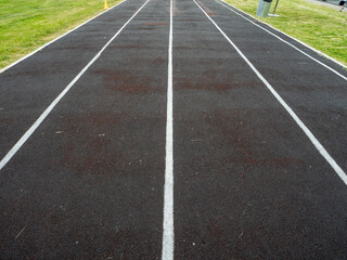 A track is shown with white lines and a black surface
