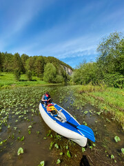 A person is leisurely paddling in a kayak on a beautiful river, enjoying the scenic views and the tranquility of nature around them, surrounded by the gentle flowing water