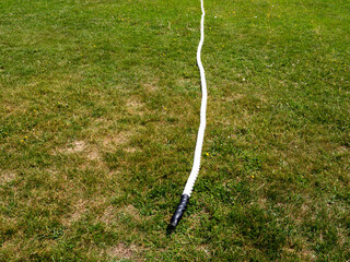 A white rope is laying on the grass