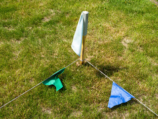 A green, blue and white flag is on a grassy field