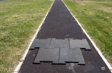 A black and white photo of a path with a black and white mat on the ground