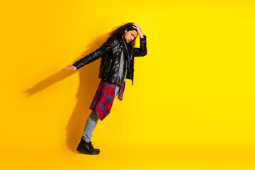 Stylish young man with trendy outfit posing against a bright yellow background, expressing modern lifestyle and fashion