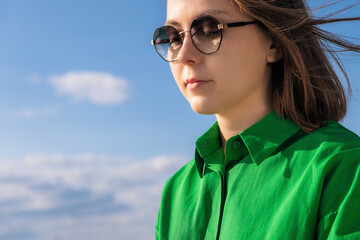 young woman. A girl in green shirt, and sunglasses