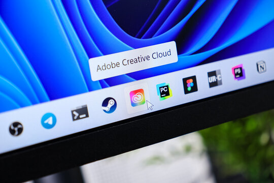 Poznan, Poland - June 6, 2025: Adobe Creative Cloud application prominently displayed on a modern computer screen, with a mouse cursor pointing at its icon