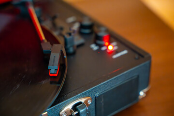 Close-up of record player needle tracking vinyl grooves during playback. Analog sound detail...