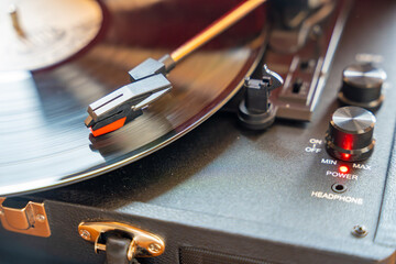 Close-up of record player needle tracking vinyl grooves during playback. Analog sound detail...