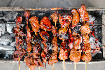 Sate or Chicken satay, lamb satay grilled on burning charcoal and causing a lot of smoke. Traditional food from Indonesia. Top view