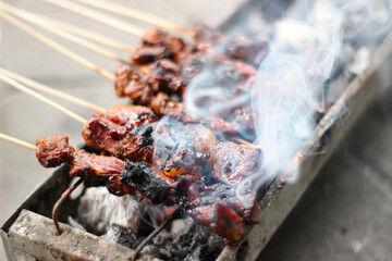 Sate or Chicken satay, lamb satay grilled on burning charcoal and causing a lot of smoke. Traditional food from Indonesia