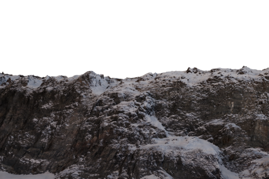 A stark, low-angle shot of a snow-dusted mountain range at dawn or dusk, the peaks jagged and dark against a black background.  The snow is patchy, clinging to the rough, rocky surface
