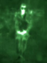 A passerby in black glasses. Looking into the distance on the night street. Image from thermal...