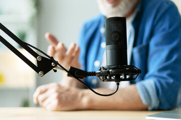 Radio host speaking into microphone during podcast recording selective focus. closeup
