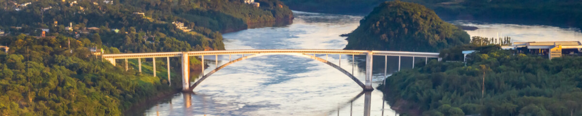 Border between Brazil and Paraguay and connects Foz do Iguacu to Ciudad del Este. Ponte da Amizade in Foz do Iguacu. Aerial view of the Friendship Bridge with Parana river. Web banner in aerial view.