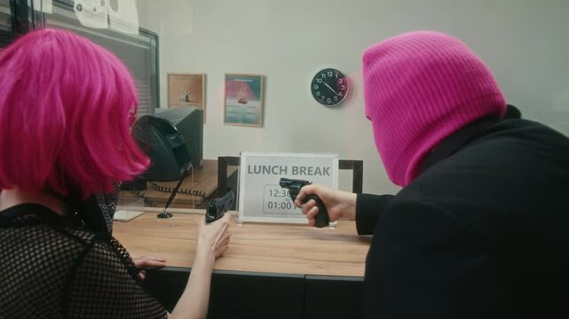 Female bank worker meeting two masked robbers pointing guns at woman then placing sign on cash counter saying office is closed for lunch break