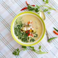 a plate of hot and sour sea bass soup with coconut milk and lime on the table