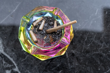 Colorful Ashtray With Remnants Of Cannabis Joints On A Marble Table