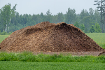 Wood Chip Piles in Rural Landscape – Biomass Energy Resource. Timber Shredding Storage for...