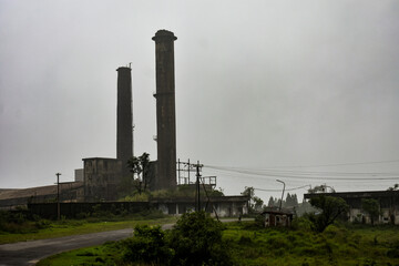 Old, abandoned factory with tall smokestacks under a gloomy sky in Meghalaya. 