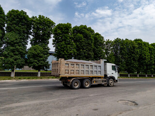 The truck filled with a load rides along the road