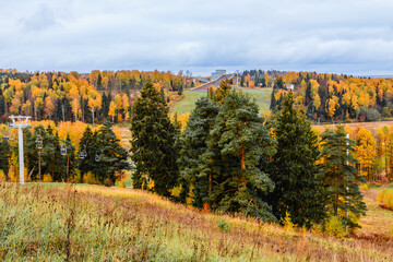 Ski resort landscape showcasing beautiful autumn foliage and ski lifts in the distance