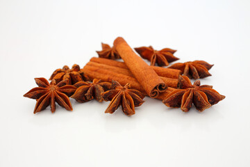 Cinnamon sticks and star aniseed on white reflective background. Selective focus. Macro.