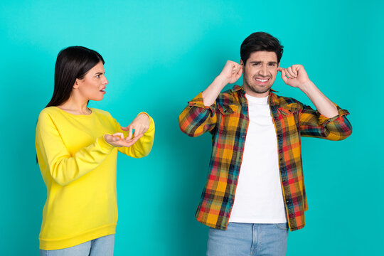Young couple arguing with expressive gestures on a vibrant turquoise background highlighting emotions and communication dynamics