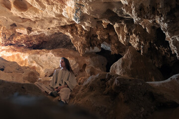 Woman traveler in the Djara Cave in Egypt with impressive stalagmites and natural rock formations. ...