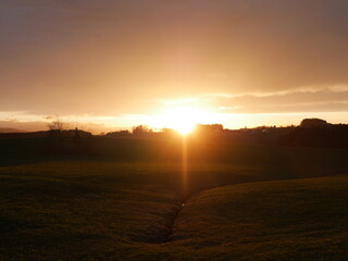 Beautiful sunset over a field with a river running through it