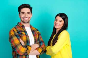 Cheerful duo posing against a teal background showcasing friendship, style, and positivity with bright smiles and casual attire